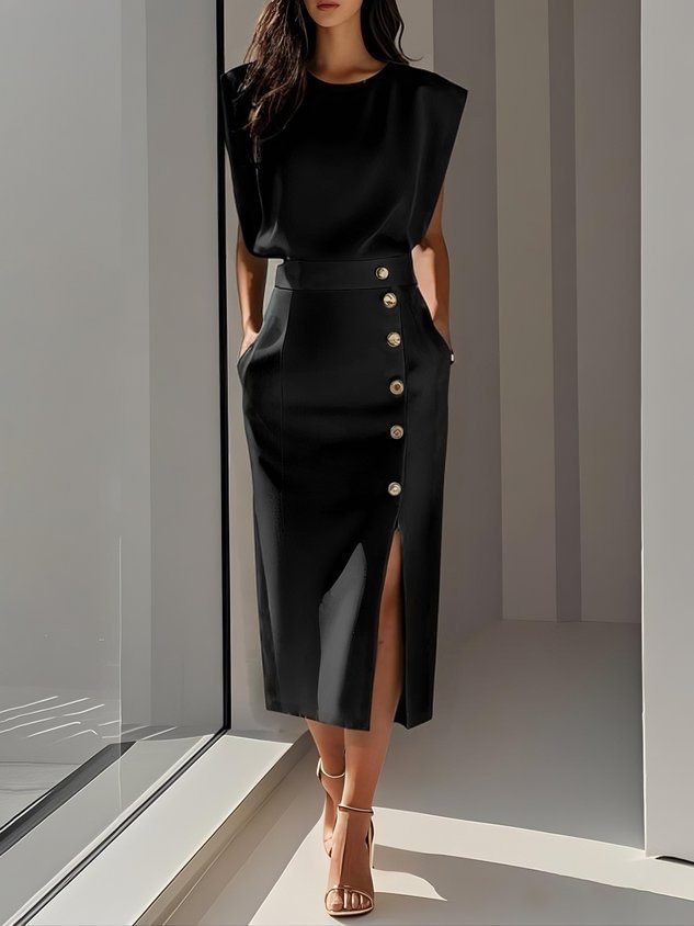 Black sleeveless top and button-front midi skirt with side slit, styled with heels near window