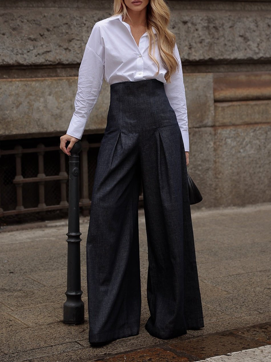 Woman in white button-down shirt and high-waisted wide-leg dark denim pants, urban street style