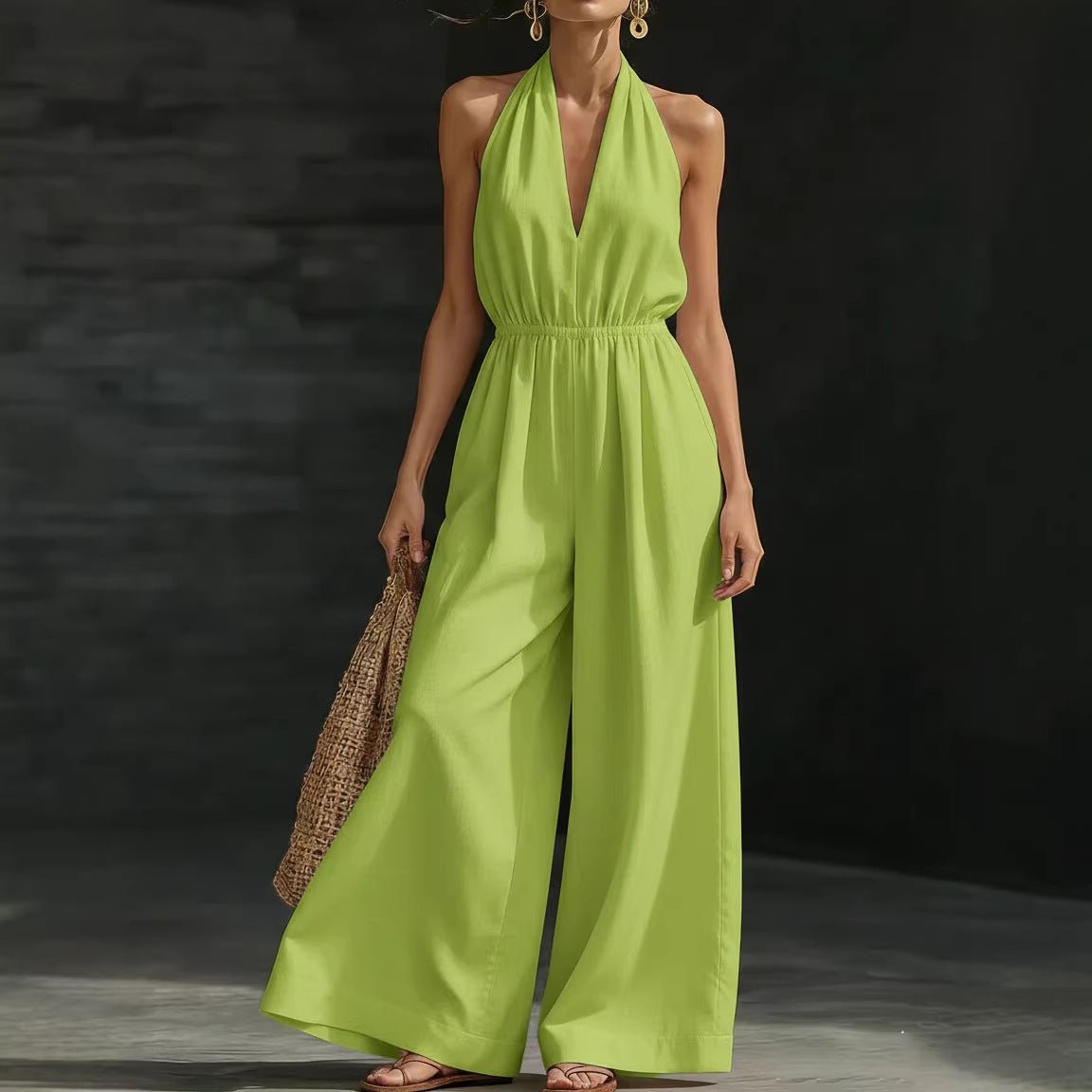 Lime green halter neck jumpsuit with wide legs and deep V-neck, styled with woven bag and sandals
