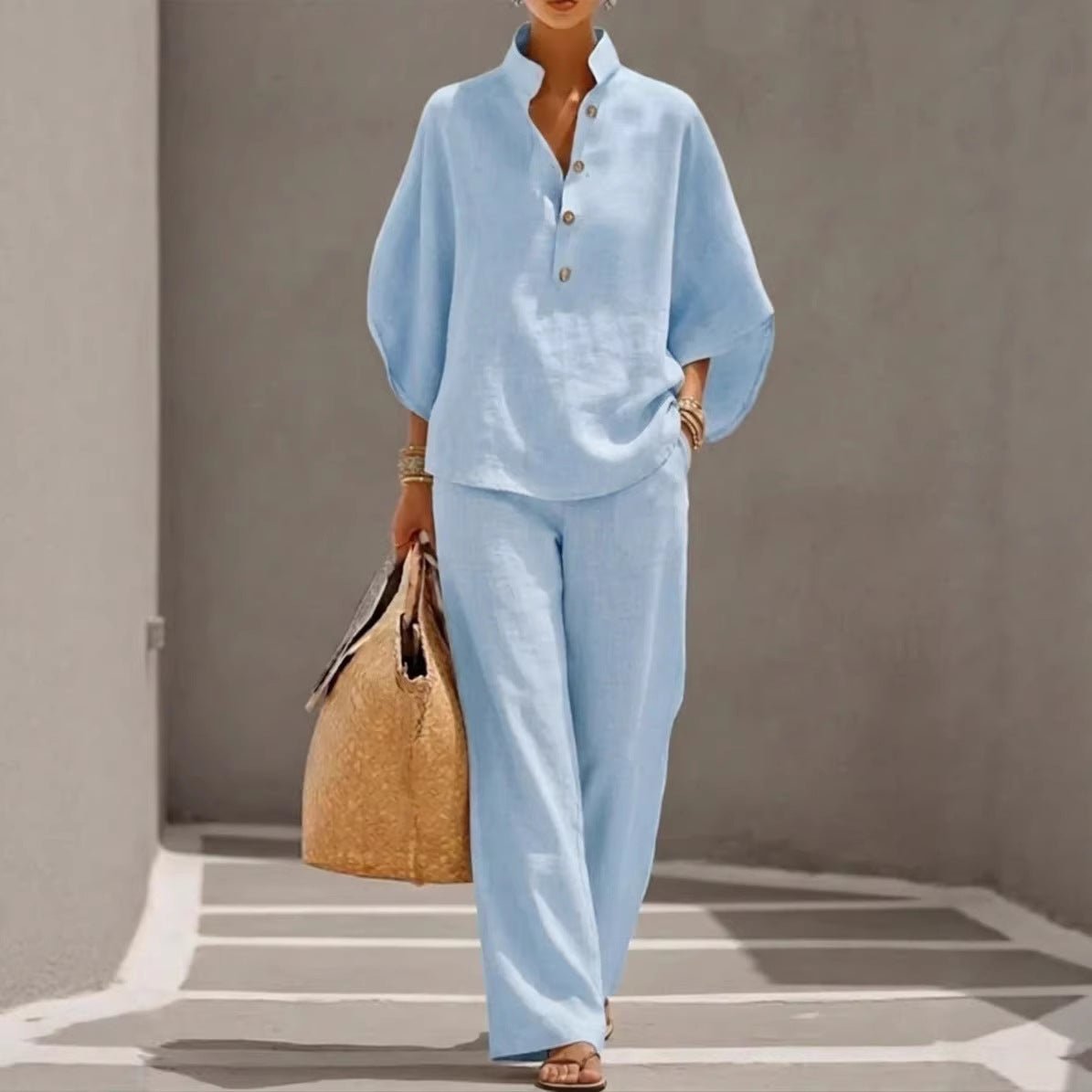 Light blue linen matching set with button-up top and wide-leg pants, styled with woven tote bag